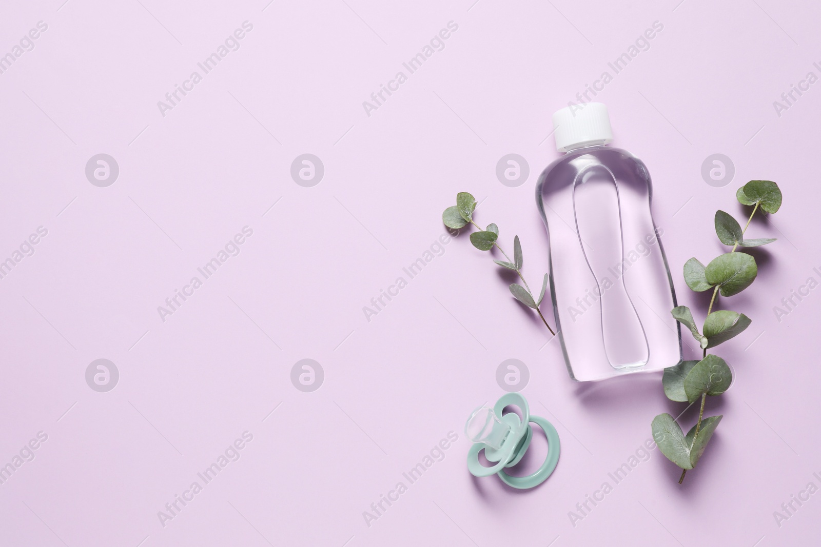 Photo of Baby oil, pacifier and eucalyptus on lilac background, top view. Space for text