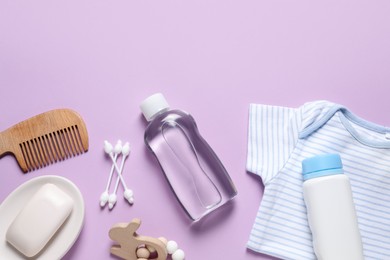 Photo of Baby oil, clothes and bath accessories on lilac background, flat lay