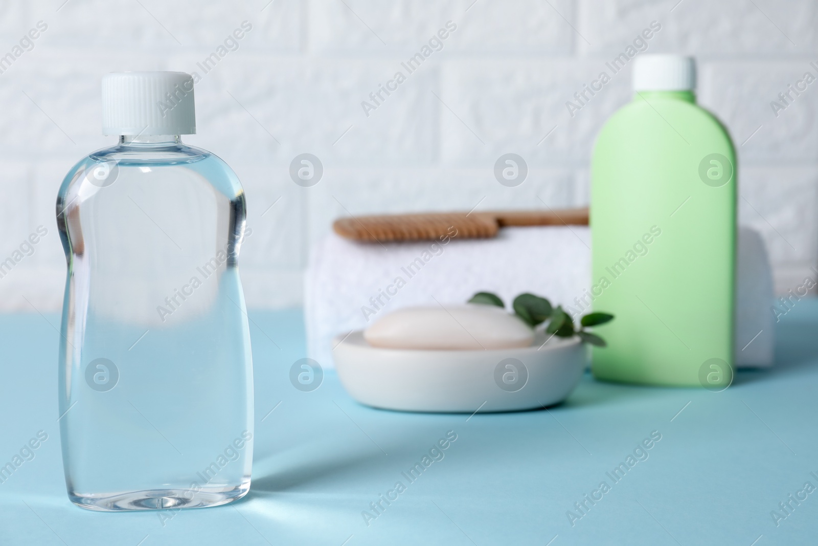 Photo of Baby oil and bath accessories on blue table