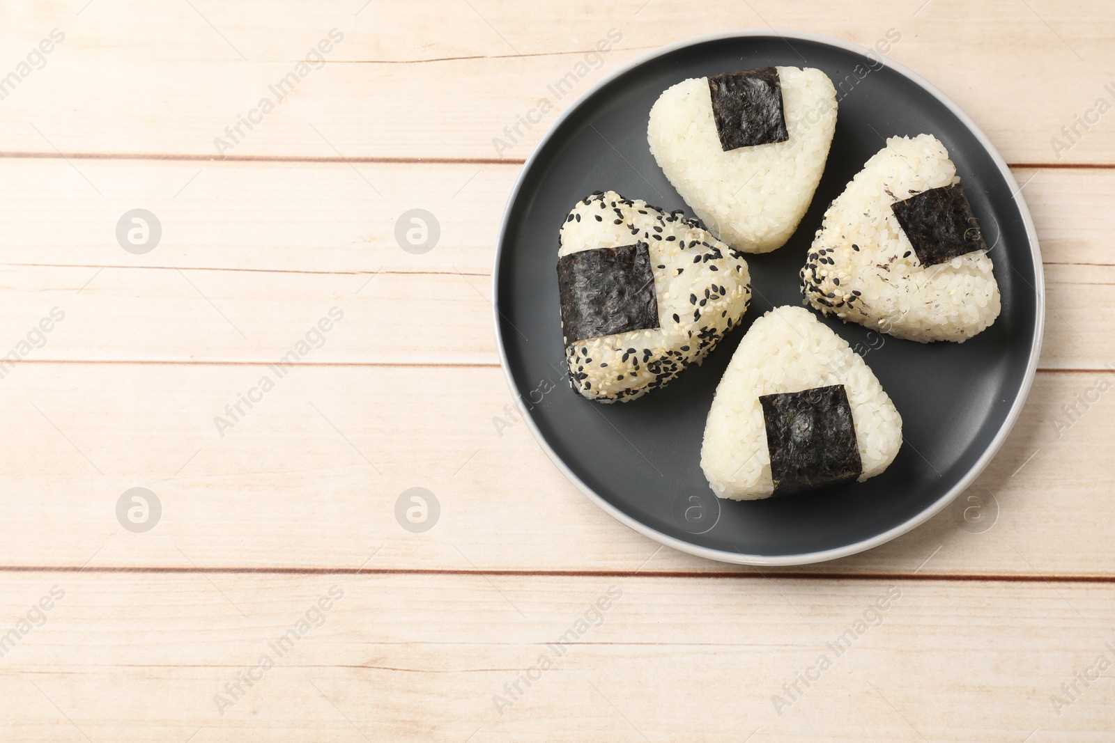 Photo of Traditional Japanese dish. Rice balls (onigiri) on wooden table, top view. Space for text