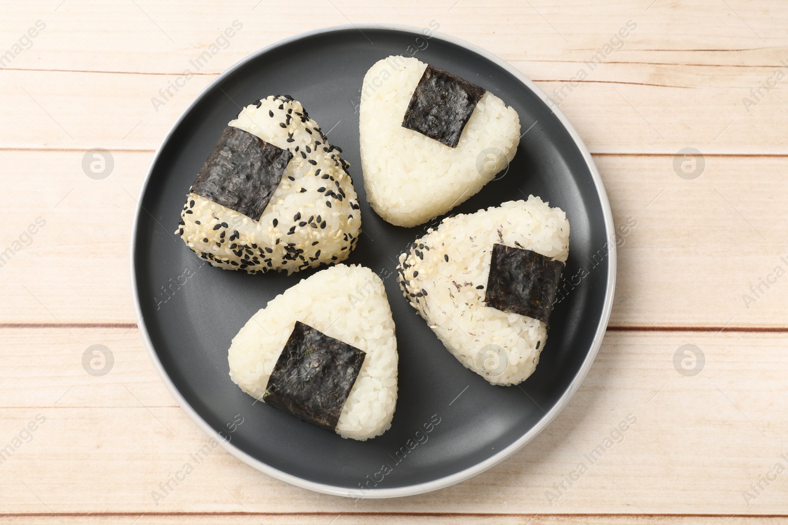 Photo of Rice balls (onigiri) on wooden table, top view. Traditional Japanese dish