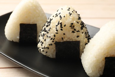 Photo of Rice balls (onigiri) on wooden table, closeup. Traditional Japanese dish