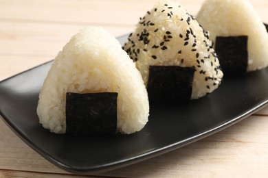 Photo of Rice balls (onigiri) on wooden table, closeup. Traditional Japanese dish