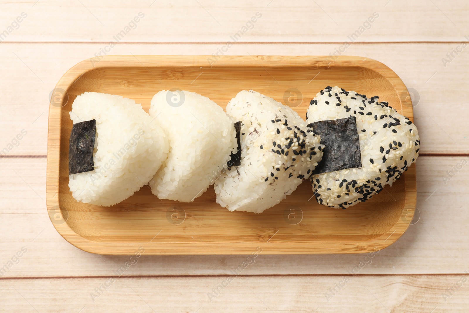 Photo of Rice balls (onigiri) on wooden table, top view. Traditional Japanese dish