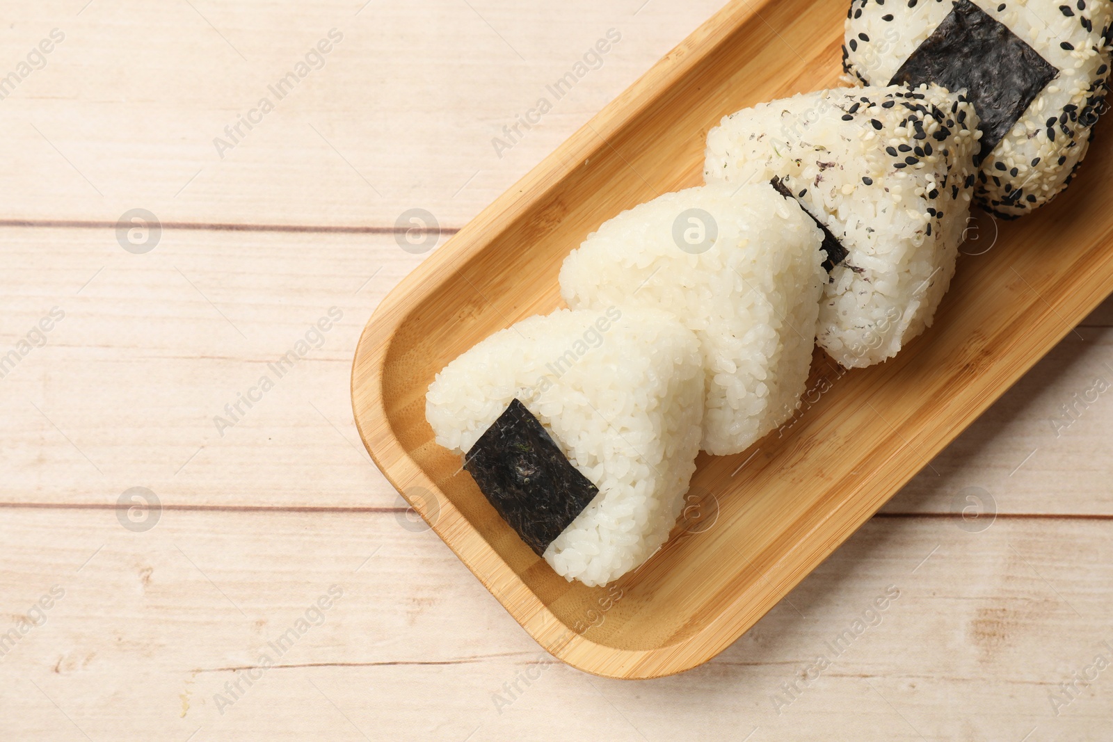 Photo of Traditional Japanese dish. Rice balls (onigiri) on wooden table, top view. Space for text