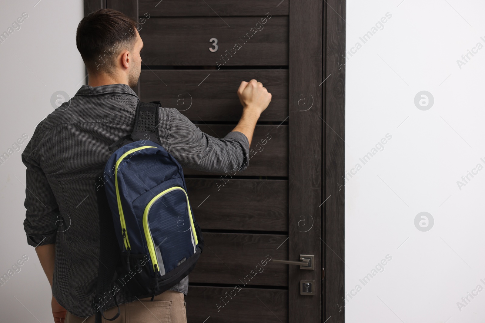 Photo of Man knocking on door to his friends apartment