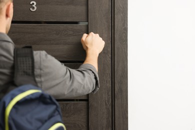 Photo of Man knocking on door to his friends apartment, closeup