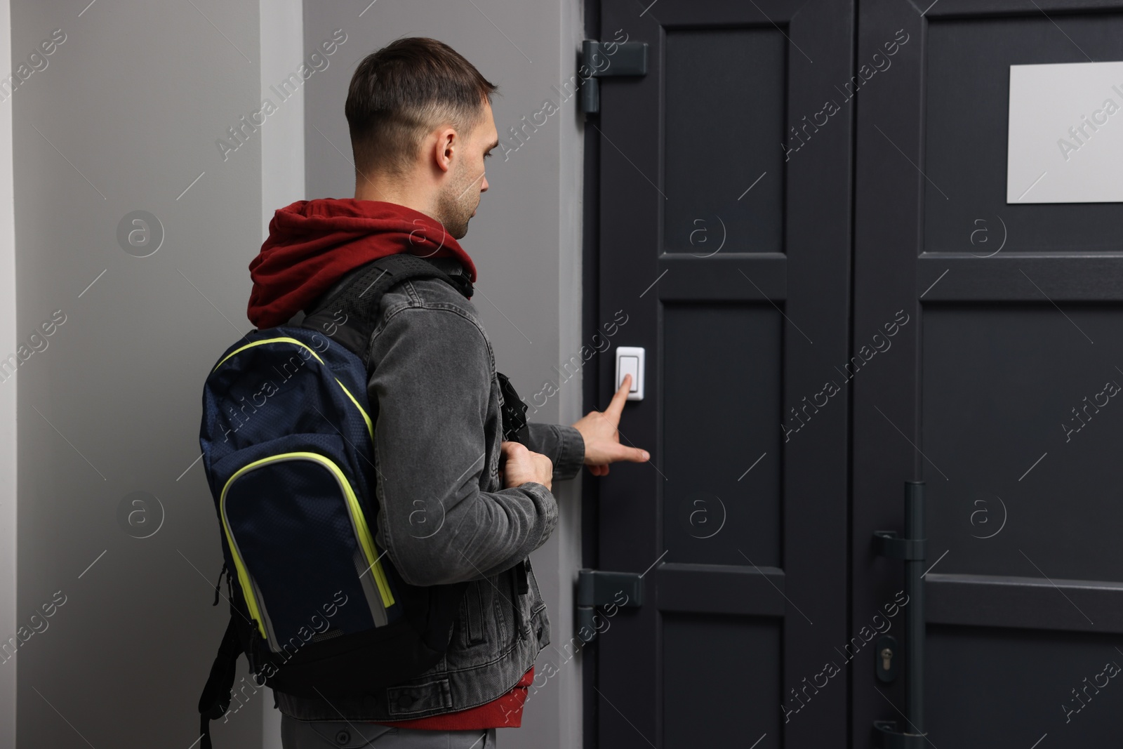 Photo of Man ringing doorbell of his friends apartment