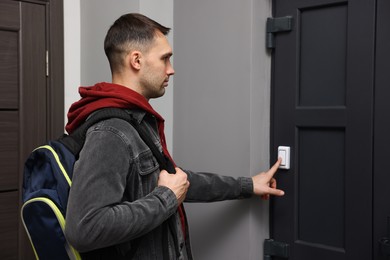 Photo of Man ringing doorbell of his friends apartment