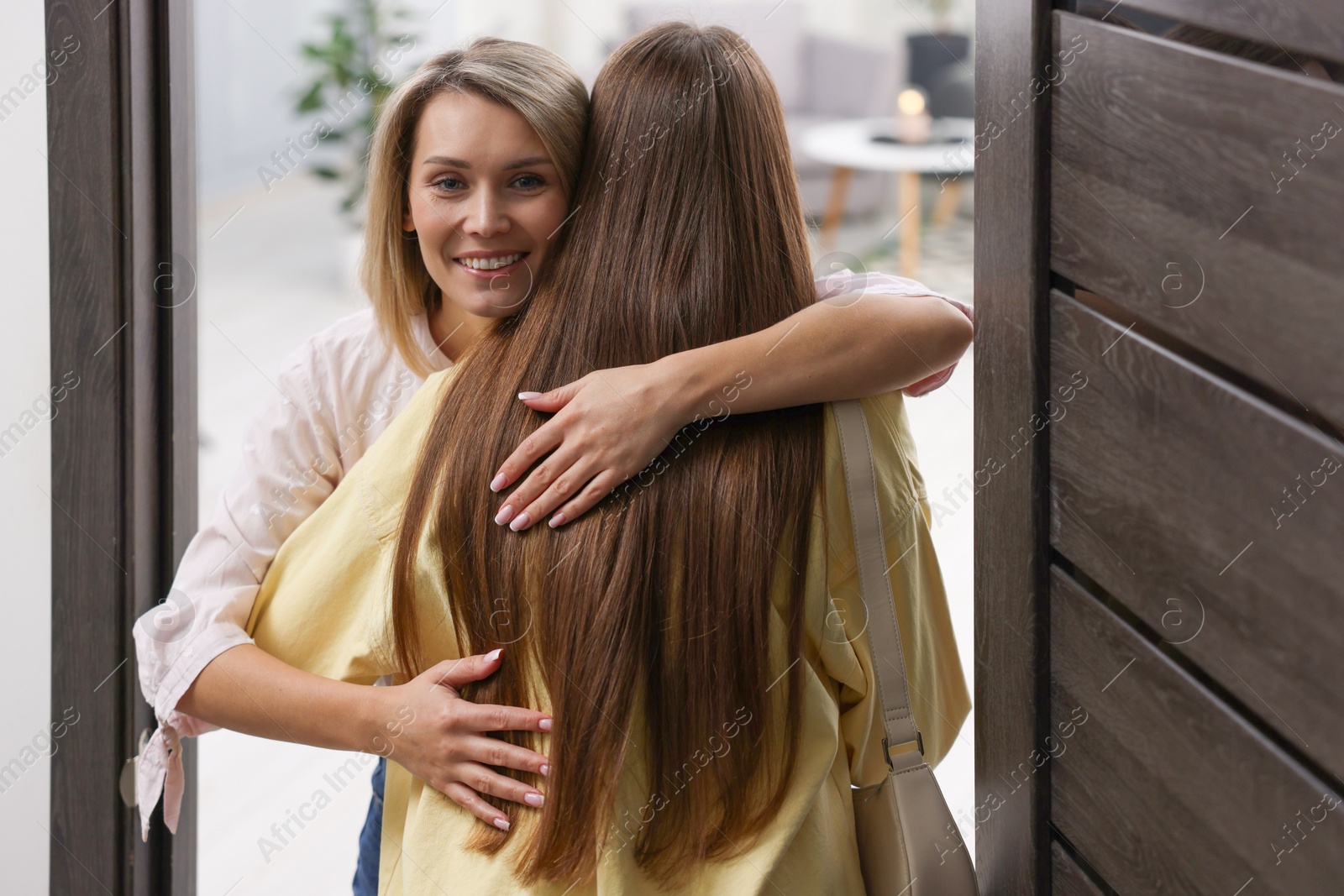 Photo of Happy woman welcoming friend to her apartment