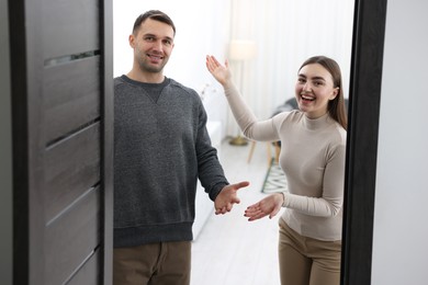 Photo of Happy couple welcoming guests to their apartment