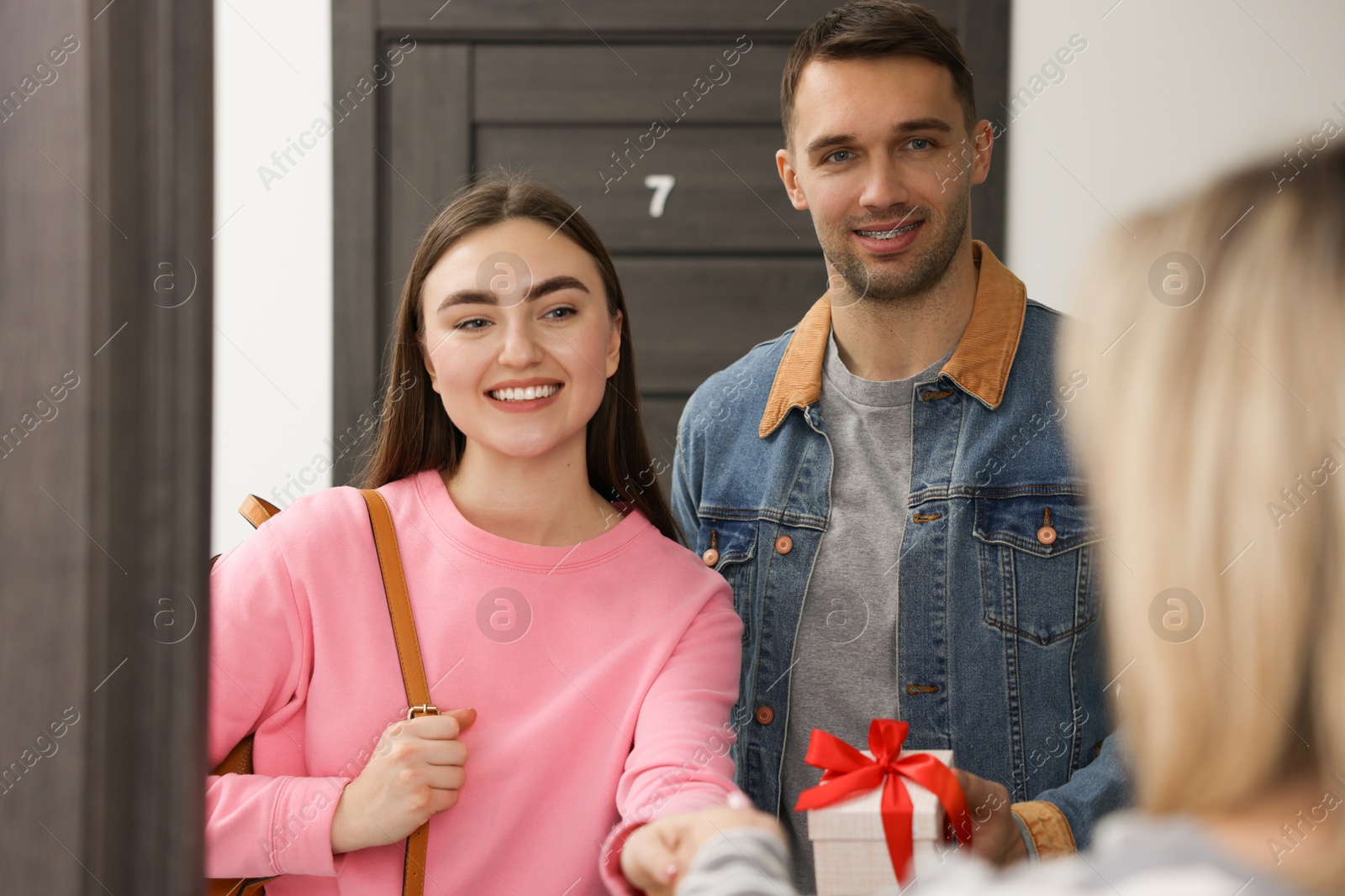 Photo of Lovely couple giving housewarming gift to their new neighbor