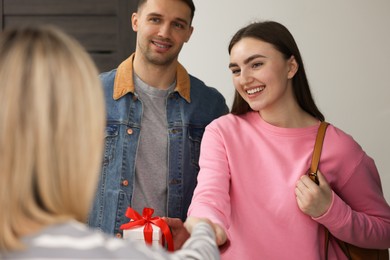 Woman welcoming new neighbors to her apartment