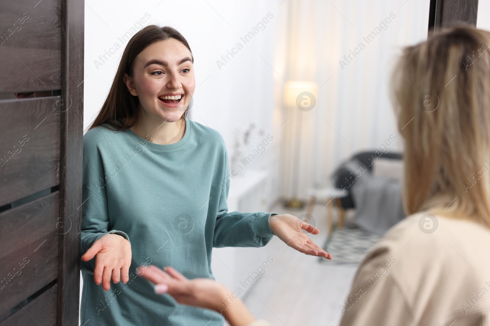 Photo of Surprised woman welcoming guest to her apartment