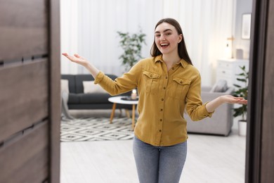 Photo of Happy woman welcoming friend to her house