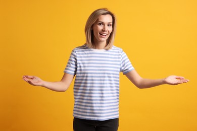 Photo of Happy woman welcoming guests on orange background