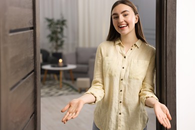 Photo of Happy woman welcoming guests to her house