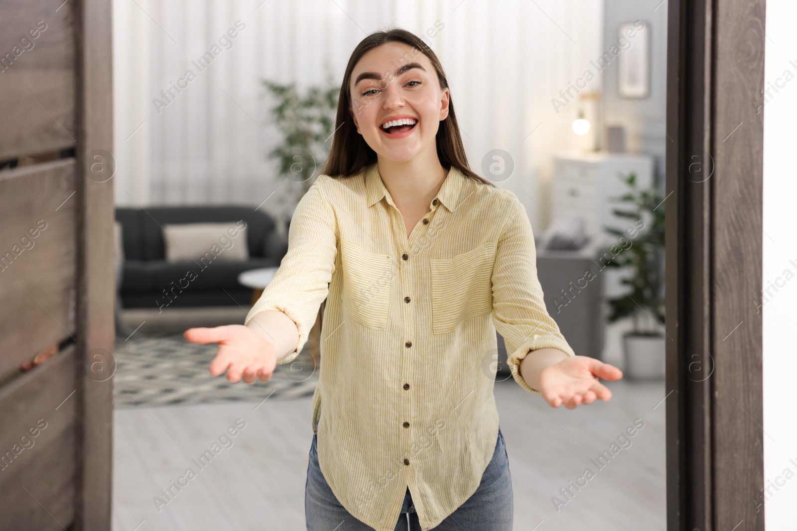 Photo of Happy woman welcoming guests to her house