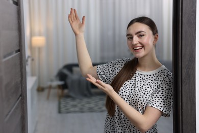 Photo of Happy woman welcoming guests to her house