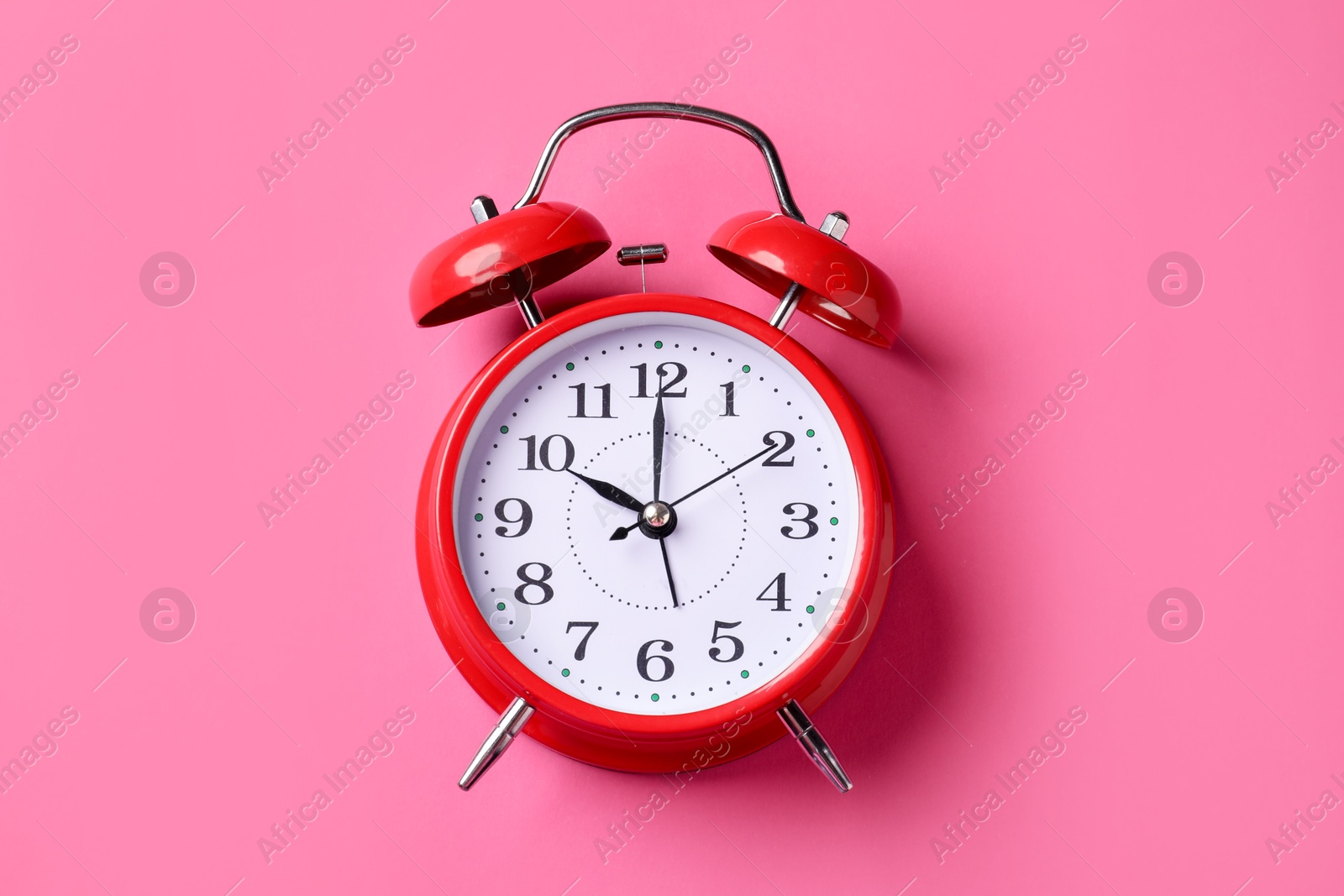 Red alarm clock on pink background, top view Photo of Red alarm clock on pink background, top view