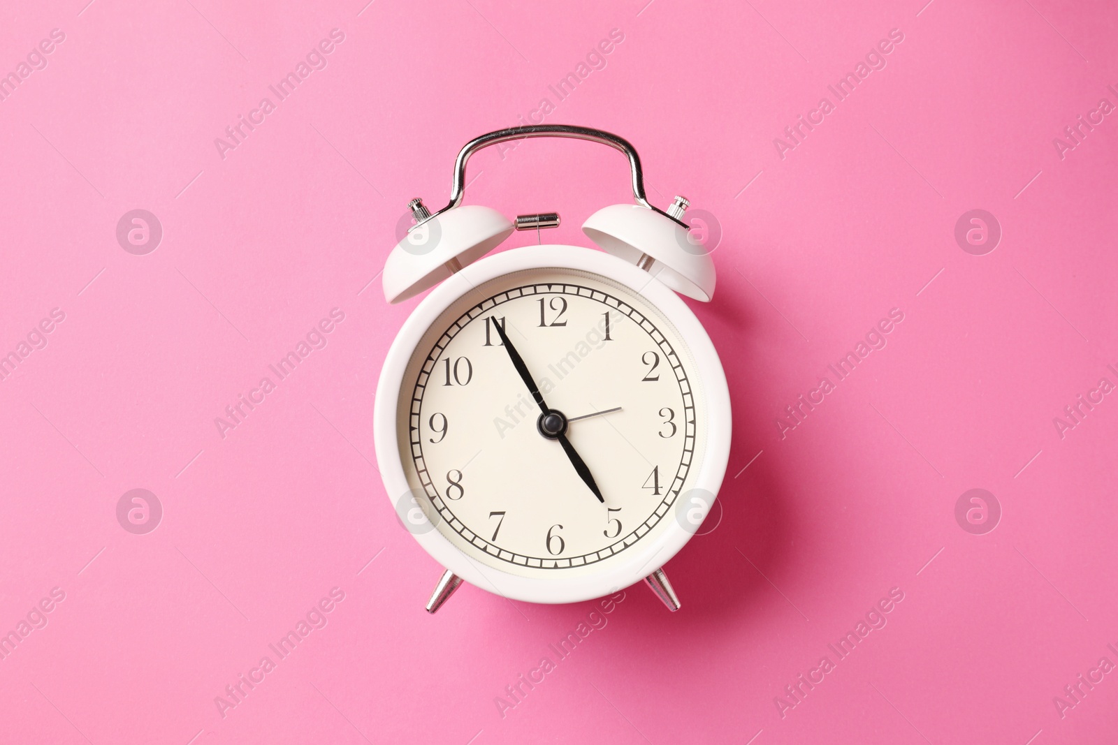 White alarm clock on pink background, top view Photo of White alarm clock on pink background, top view