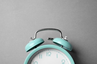 Photo of Turquoise alarm clock on grey background, top view