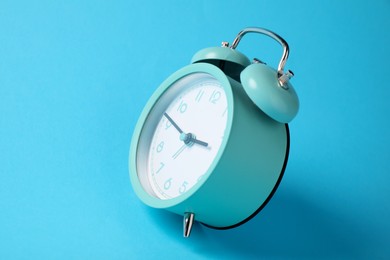 Photo of Turquoise alarm clock on light blue background