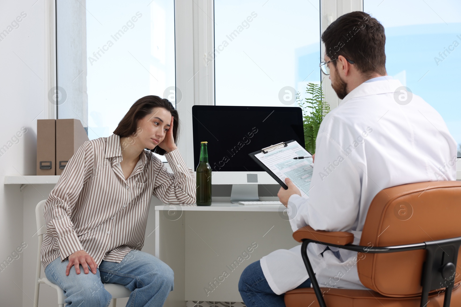 Photo of Alcoholic woman having appointment with healthcare specialist in clinic. Addiction treatment