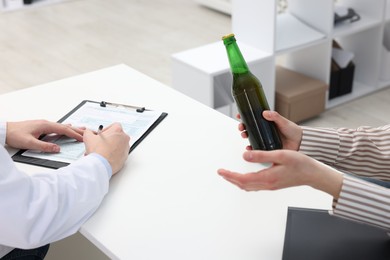 Photo of Alcoholic woman having appointment with healthcare specialist in clinic, closeup. Addiction treatment