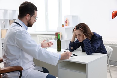 Photo of Alcoholic woman having appointment with healthcare specialist in clinic. Addiction treatment