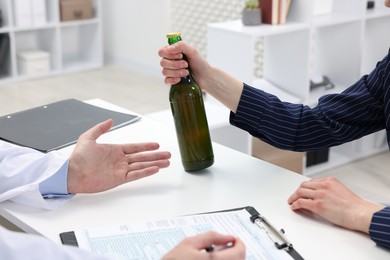 Photo of Alcoholic woman having appointment with healthcare specialist in clinic, closeup. Addiction treatment