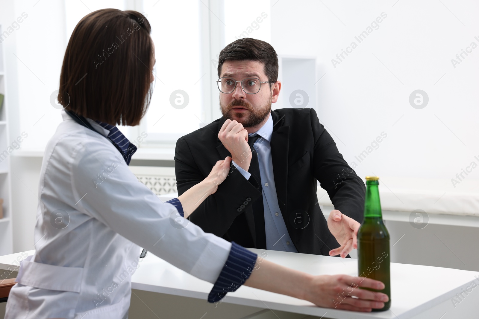 Photo of Alcoholic man having appointment with healthcare specialist in clinic. Addiction treatment