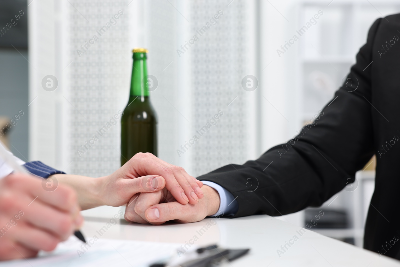 Photo of Alcoholic man having appointment with healthcare specialist in clinic, closeup. Addiction treatment