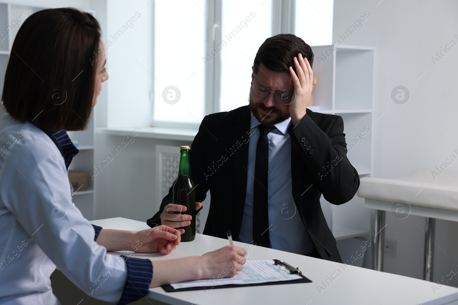 Photo of Alcoholic man having appointment with healthcare specialist in clinic. Addiction treatment