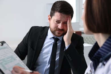 Photo of Alcoholic man having appointment with healthcare specialist in clinic. Addiction treatment