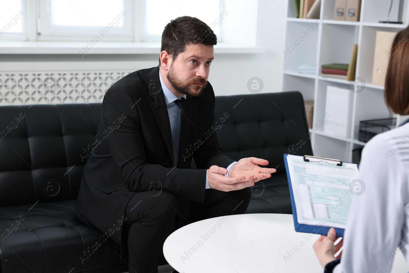 Photo of Alcoholic man having appointment with healthcare specialist in clinic. Addiction treatment