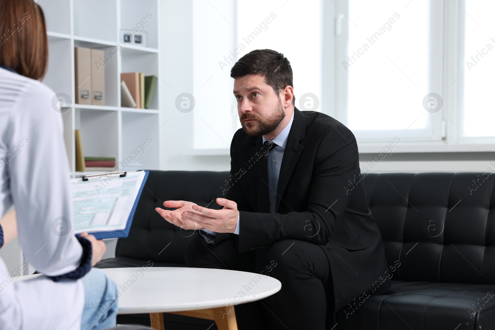 Photo of Alcoholic man having appointment with healthcare specialist in clinic. Addiction treatment