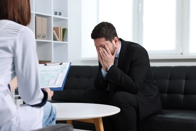 Photo of Alcoholic man having appointment with healthcare specialist in clinic. Addiction treatment