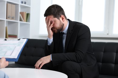 Photo of Alcoholic man having appointment with healthcare specialist in clinic. Addiction treatment