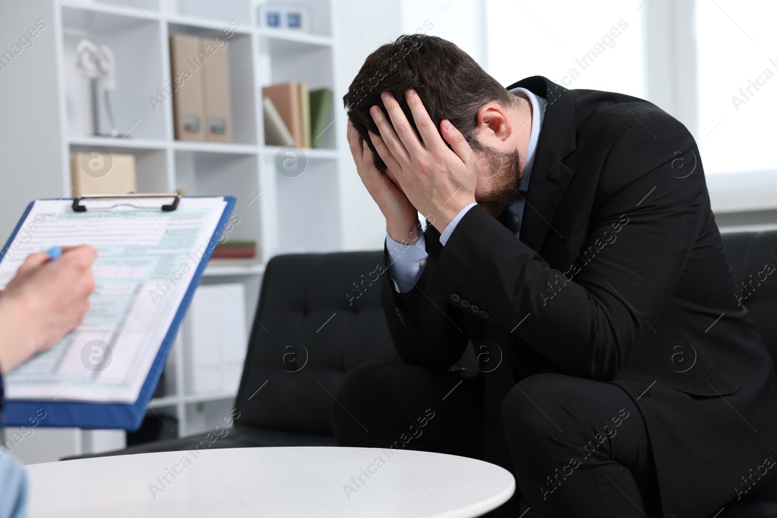 Photo of Alcoholic man having appointment with healthcare specialist in clinic. Addiction treatment