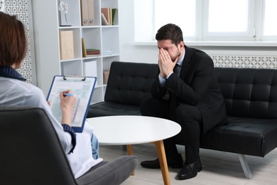 Photo of Alcoholic man having appointment with healthcare specialist in clinic. Addiction treatment