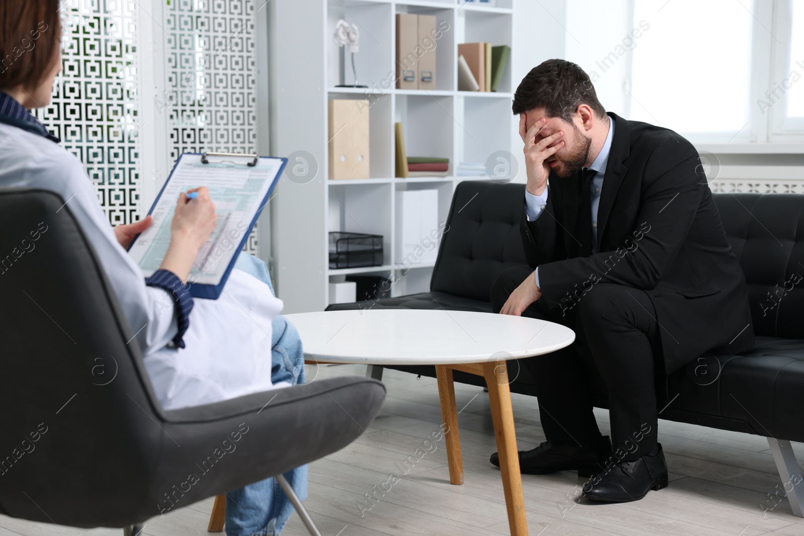 Photo of Alcoholic man having appointment with healthcare specialist in clinic. Addiction treatment