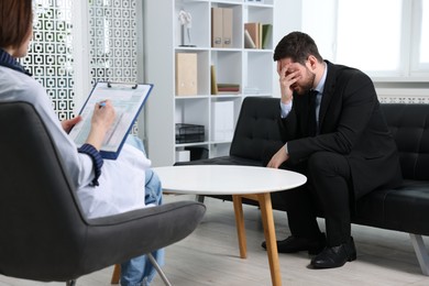 Photo of Alcoholic man having appointment with healthcare specialist in clinic. Addiction treatment