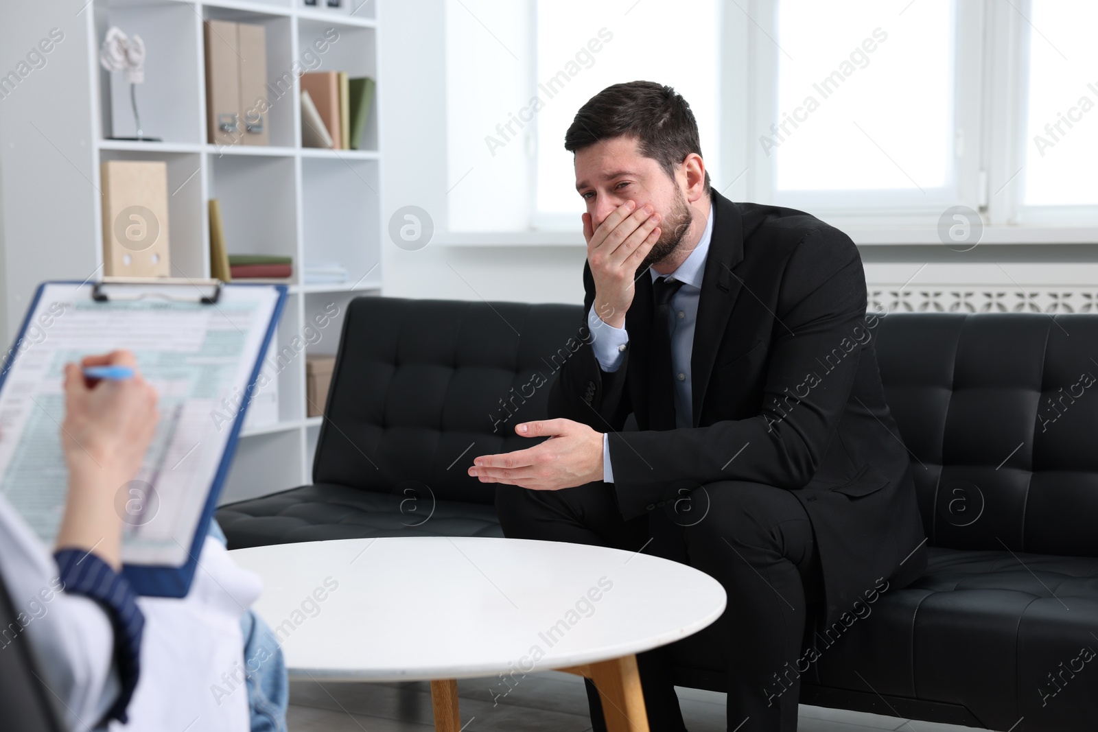 Photo of Alcoholic man having appointment with healthcare specialist in clinic. Addiction treatment