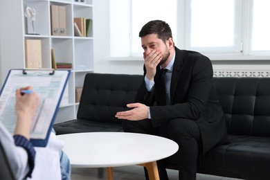 Photo of Alcoholic man having appointment with healthcare specialist in clinic. Addiction treatment