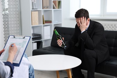 Photo of Alcoholic man having appointment with healthcare specialist in clinic. Addiction treatment