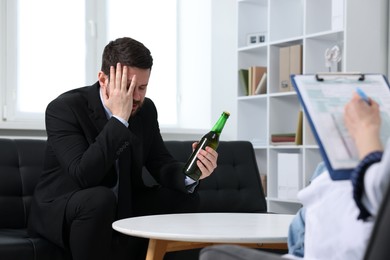 Photo of Alcoholic man having appointment with healthcare specialist in clinic. Addiction treatment