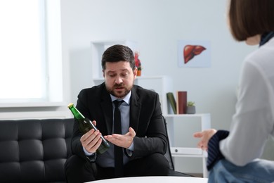 Photo of Alcoholic man having appointment with healthcare specialist in clinic. Addiction treatment