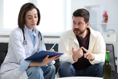 Photo of Alcoholic man having appointment with healthcare specialist in clinic. Addiction treatment