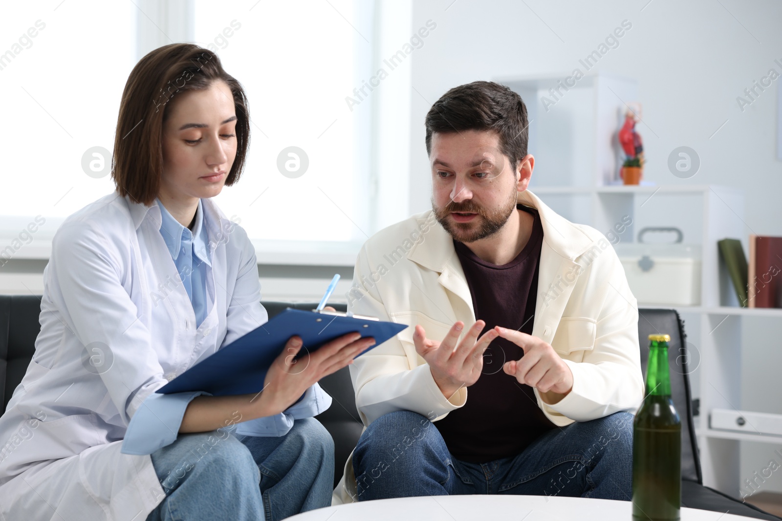 Photo of Alcoholic man having appointment with healthcare specialist in clinic. Addiction treatment